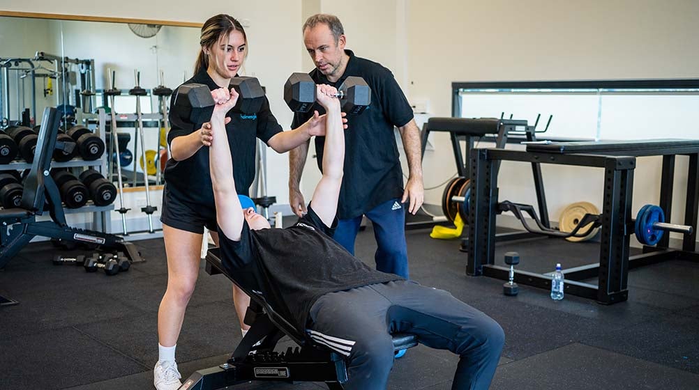 Holmesglen teacher and students in Holmesglen's fitness facility.