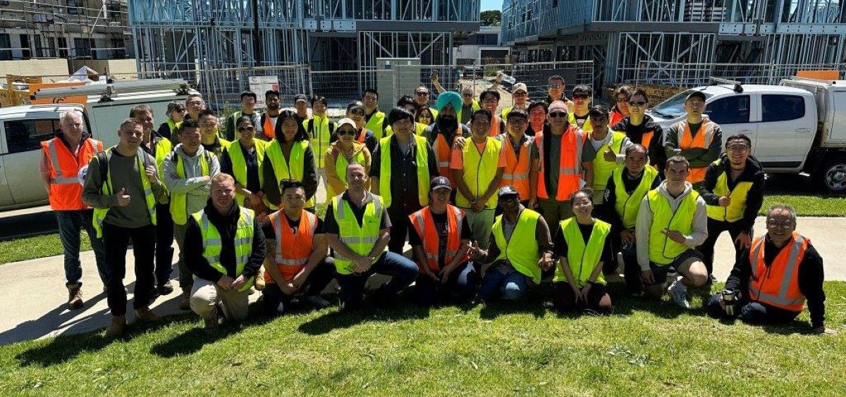 A Group of Students Taking a Photo in Front of Construction Buildings