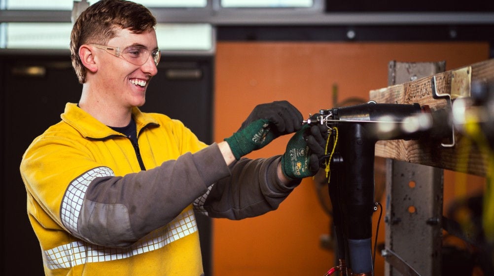 A student learning electrical skills at Holmesglen