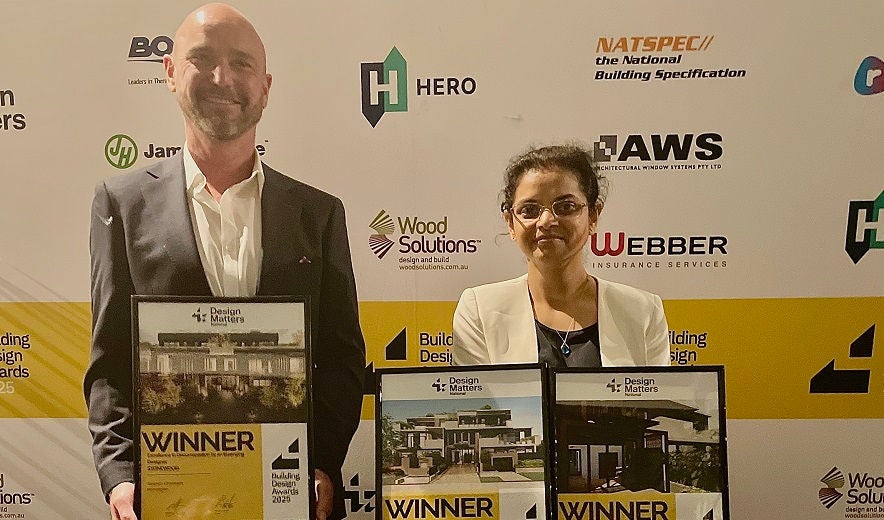 Two Holmesglen building design students hold their award certificates.