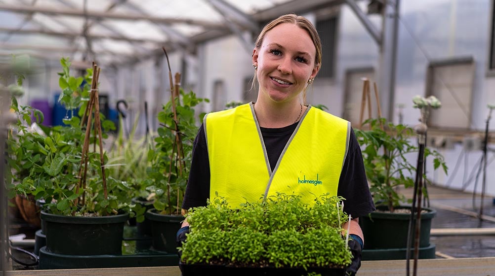 Photo of a Holmesglen student holding a tray of small plants.