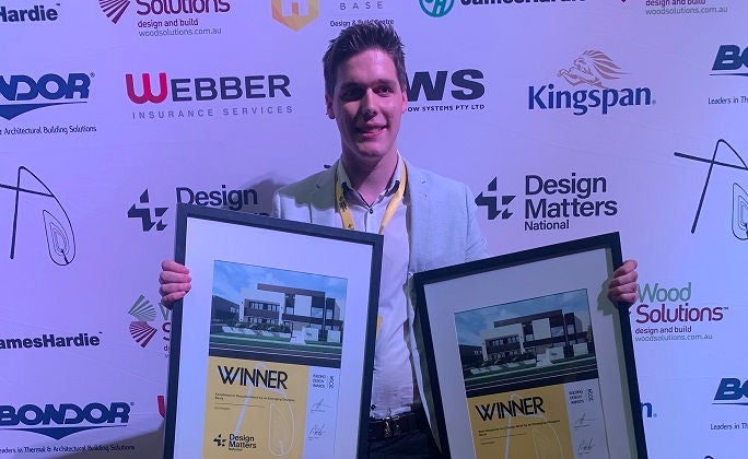 Holmesglen graduate Riley Watts holds two framed award certificates.