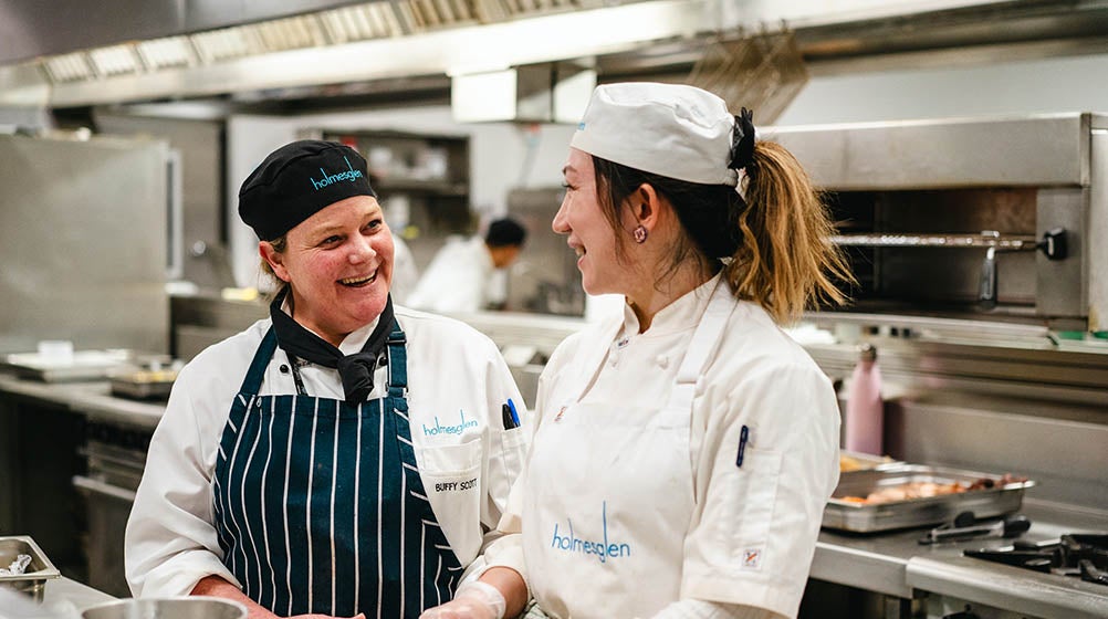 Holmesglen teacher with students in the kitchen.