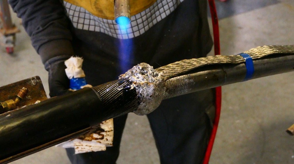A student welding a cable as part of their practical training