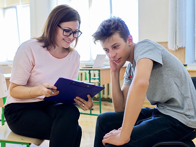 Woman school psychologist talking and helping student, male teenager. Mental health of adolescents, psychology, social issues, professional help of counselor