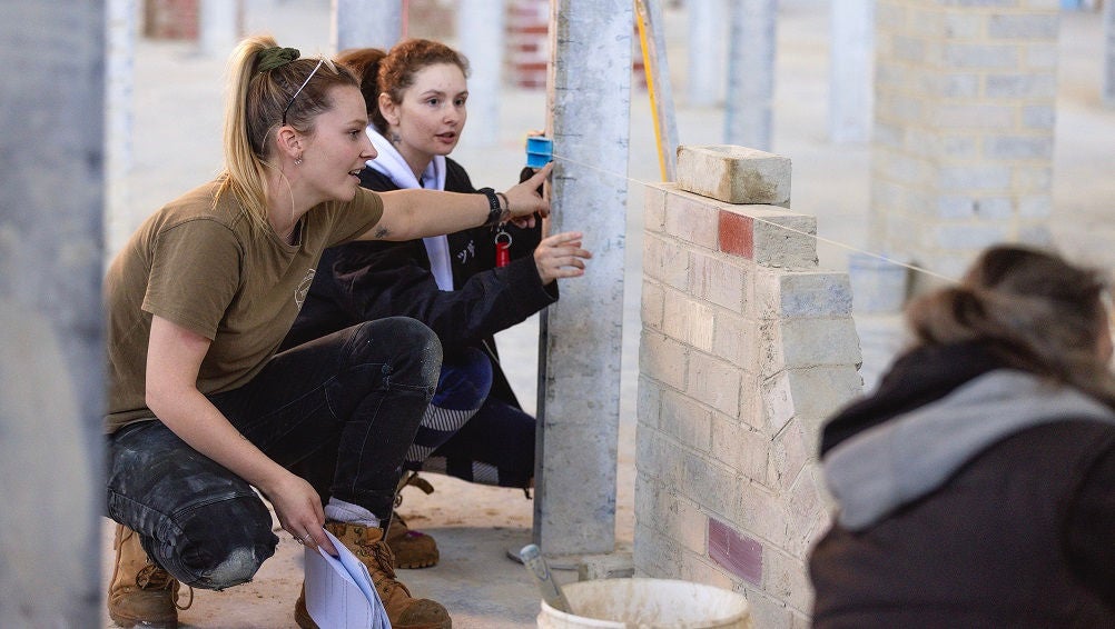 Students work on a brick wall project in a trades workshop