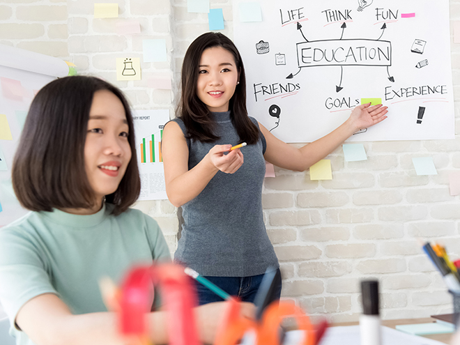 Young Asian female college student making a presentation in front of classroom