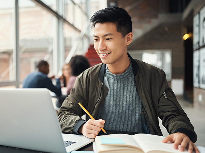 College student, asian man and studying on laptop at campus, research and education test, exam books and course project. Happy Japanese university student, knowledge and learning online technology