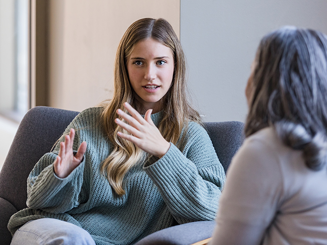 The young adult university student talks with her mature peer about her previous experiences.