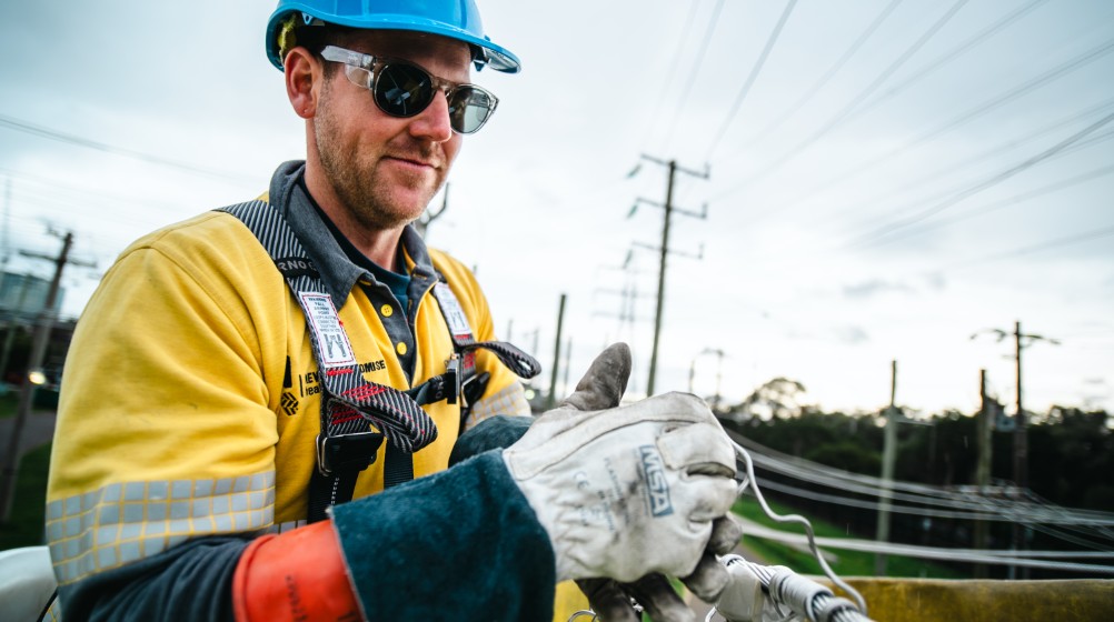 Image of a man working under an overhead powerline.
