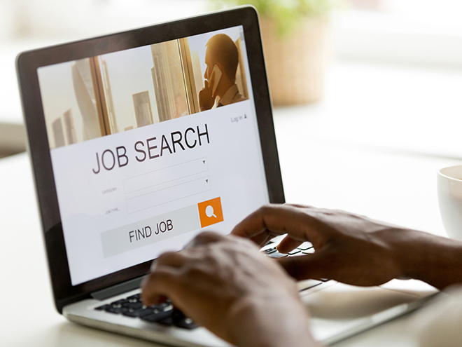 African man browsing work opportunities online using job search computer app, black jobless seeker looking for new vacancies on website page at laptop screen, recruitment concept, rear close up view