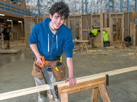A Holmesglen vocational student works on a wood-cutting project in the workshop